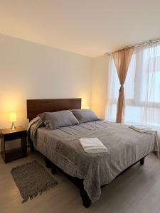 a bedroom with a large bed and a window at Acogedor Apartamento en Laguna del Mar in La Serena