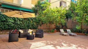 a patio with couches and chairs and an umbrella at Maison Chrilò, Sorrento in Sorrento