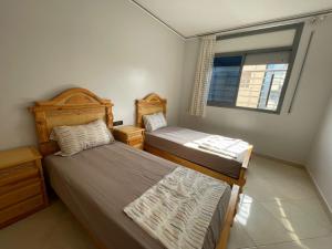 a bedroom with two beds and a window at appartement boukidan in Al Hoceïma