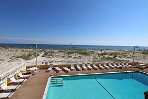 una piscina con sedie a sdraio e la spiaggia di Driftwood Towers a Gulf Shores