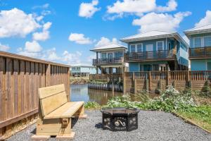 un banc en bois assis devant certaines maisons dans l'établissement Cinema Shores – A Movie-Themed Beachfront Escape!, à Mustang Beach