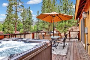 a hot tub on a deck with an umbrella at Eagle ridge views #1648 in Big Bear Lake