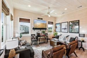 un salon rempli de meubles et d'un ventilateur de plafond dans l'établissement Cinema Shores – A Movie-Themed Beachfront Escape!, à Mustang Beach
