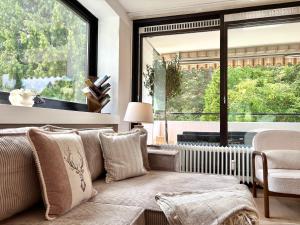 a living room with a couch and a large window at HyggeLiving - DELUXE - 90qm - Balkon - Gartenblick - 55 Zoll TV - Boxspringbetten - Hunde - Kinder - Fahrradkeller in Bad Harzburg