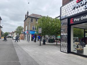 a city street with people walking on the sidewalk at Studio flat central harrow in Harrow