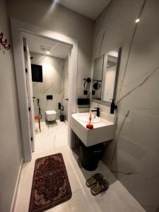 a bathroom with a sink and a toilet and a mirror at UNDD Rouge in Jeddah +18 photos