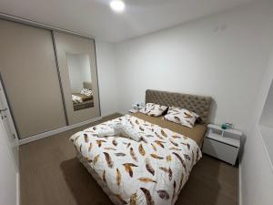 Un dormitorio con una cama y un espejo grande. en Mona lux, en Novi Sad