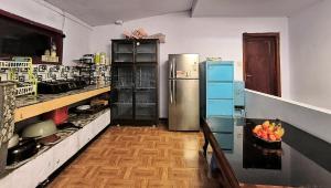 a kitchen with a refrigerator and a bowl of fruit on a table at Elen Homestay by ABM in Bromo