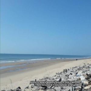 una playa con un montón de rocas y el océano en S R A vill, en Gokarna