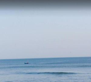 un pequeño barco en medio del océano en S R A vill, en Gokarna