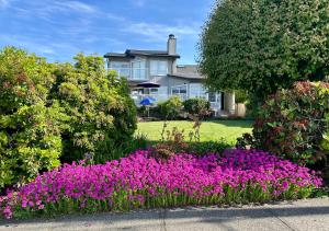 una casa con un jardín de flores delante de ella en Private Room with Mountain view, en West Vancouver