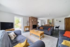 a living room with two blue couches and a fireplace at Luxury secluded coastal retreat - With hot tub in Ilfracombe