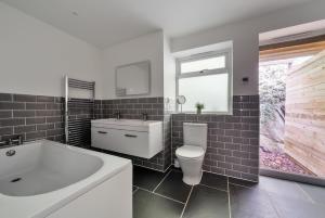 a bathroom with a tub and a toilet and a sink at Luxury secluded coastal retreat - With hot tub in Ilfracombe +69 photos