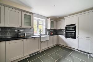 a white kitchen with white cabinets and appliances at Luxury secluded coastal retreat - With hot tub in Ilfracombe
