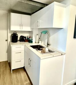 Una cocina con gabinetes blancos y un fregadero. en Private Room with Mountain view, en West Vancouver