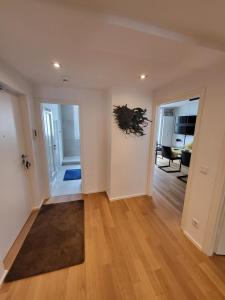 an empty living room with white walls and wood floors at TheOak Suite-Englischer Garten 2 Zimmer Apartment & Privat Parking in Munich +16 photos