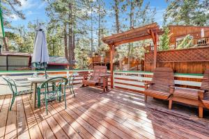 eine Terrasse mit Stühlen, einem Tisch und einem Sonnenschirm in der Unterkunft Green Squirrel Chateau #2484 in Big Bear Lake