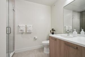 a white bathroom with a toilet and a shower at Southwestern Charm | Espadin LoHi in Denver +32 photos