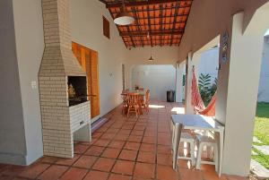 Un patio con chimenea y una mesa y sillas. en Casa Temporada Ubatuba próxima à praia, check-in e out flexíveis com 5 vagas na garagem, wifi, en Ubatuba