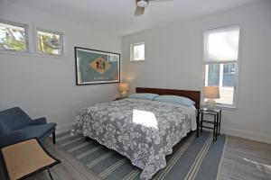 ein Schlafzimmer mit einem Bett und einem Stuhl und Fenstern in der Unterkunft Maryland avenue 35 in Rehoboth Beach + 29 Fotos
