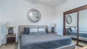 a bedroom with a bed with two mirrors on the wall at The Great Escape Modern Oceanfront in Puerto Peñasco +18 photos