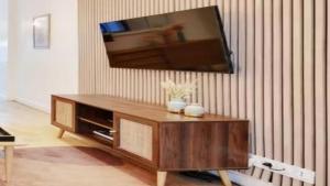 a living room with a television on a wall at Alpine Casa Vacanze Domenion Livigno in Livigno