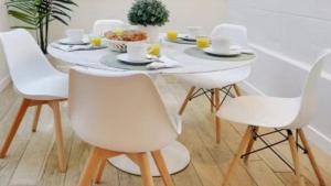 a white dining room table with white chairs at Alpine Casa Vacanze Domenion Livigno in Livigno