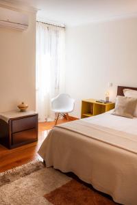 フンシャルにあるMadeira Precious Family Apartmentのベッドと机と椅子のある寝室