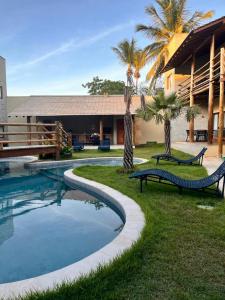 un complejo con piscina y palmeras en Reserva Flamboyant, en Barra Grande