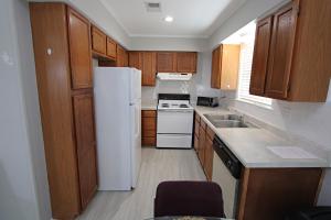 een keuken met een witte koelkast en houten kasten bij Silver Sands North in Gulf Shores