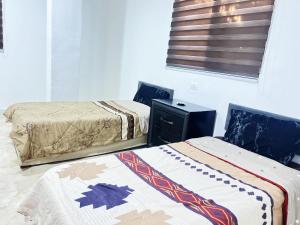 a bedroom with two beds and a window at دار زمان Zaman Suites Old Town in Al Mafraq +10 photos