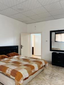a bedroom with a bed and a mirror on the wall at دار زمان Zaman Suites Old Town in Al Mafraq