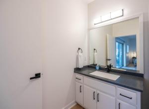 een badkamer met een wastafel en een spiegel bij Modern Downtown Studio - Bike or Walk to Trails & Dining in Bentonville