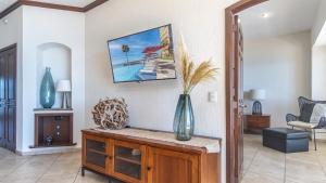 a living room with a vase on a wooden cabinet at The Great Escape Modern Oceanfront in Puerto Peñasco