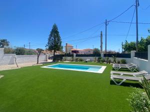 a yard with a swimming pool and green grass at Villa Paymu in Miami Platja