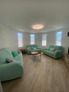 a living room with two green couches and a table at Villa Paymu in Miami Platja