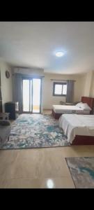 ein großes Zimmer mit zwei Betten und einem Teppich in der Unterkunft Grand hills Resort north coast in Dawwār Abū Maḩrūs