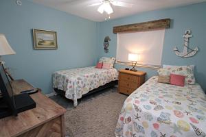 una camera da letto con due letti e un tavolo con una lampada di Driftwood Towers a Gulf Shores Altre 12 foto