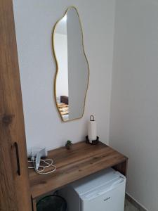 a mirror on a wall above a toilet in a bathroom at A-Niko Apartments in Vinica