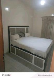 Un dormitorio con una cama grande con sábanas y almohadas blancas. en Sope Naby, en Niaga