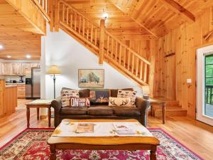 a living room with a couch and a staircase at Mountain Air Hot Tub-Fire Pit in Bryson City