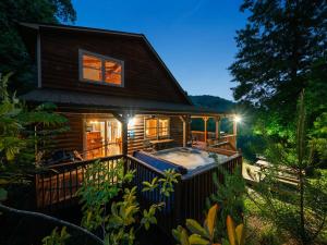 a house with a hot tub on a deck at Mountain Air Hot Tub-Fire Pit in Bryson City