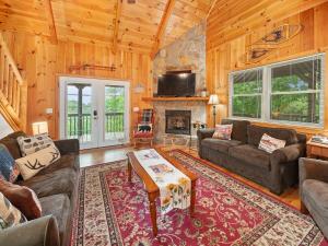 a living room with a couch and a fireplace at Mountain Air Hot Tub-Fire Pit in Bryson City