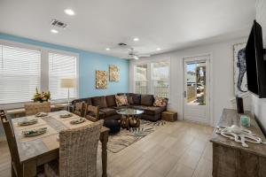 ein Wohnzimmer mit Tisch und Couch in der Unterkunft Sea Glass Cottage - Beach Gear Credit Included! in Port Aransas