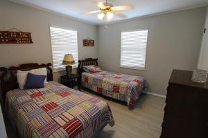 een slaapkamer met twee bedden en een plafondventilator bij Silver Sands North in Gulf Shores