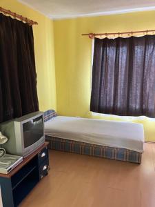 a small bedroom with a bed and a tv at Fanni Aparmanház in Miskolc
