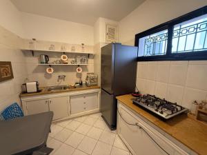 a kitchen with a refrigerator and a stove in it at Alma Martil - Appart face à la plage - plage à 50m - Juste en face! in Martil