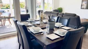 a wooden table with black chairs and a dining room at Anchorage Waterfront unit in Yamba in Yamba
