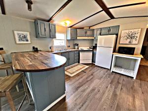 a kitchen with white appliances and a wooden floor at Oakridge Cottage in Orange Beach +27 photos