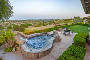 a patio with a hot tub with a table and chairs at Paso Palacio in Paso Robles